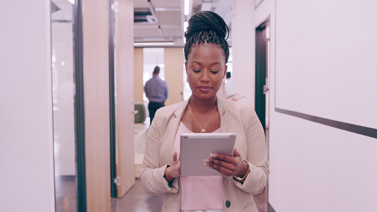 Business woman using tablet in office corridor