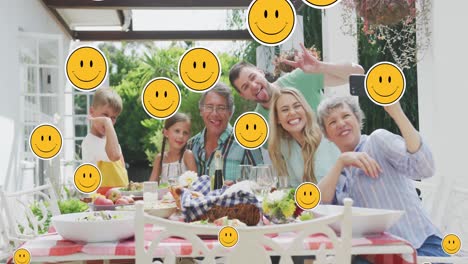 Animation-of-smiley-faces-over-happy-caucasian-family-taking-selfie-in-garden