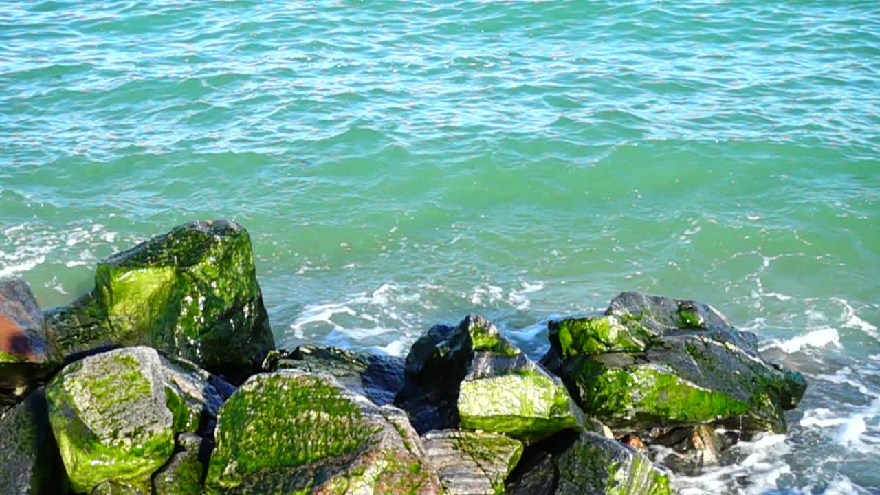 Onde del mare si infrangono contro le pietre. Riprese sulla costa. Slow motion