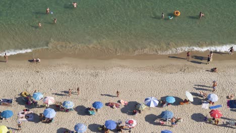playa mediterránea llena de gente desde más de 4k