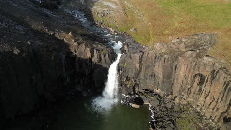 cascada desconocida en las profundidades del sur de islandia en una soleada mañana de otoño, aérea