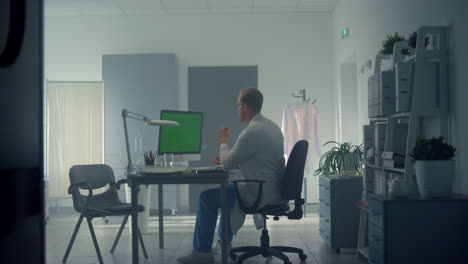 physician working chroma key computer in clinic. man consulting patient online.