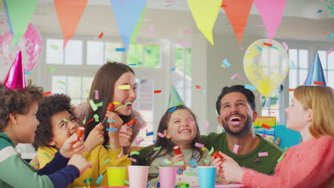 chica con padres y amigos disparando poppers de fiesta en casa para celebrar el cumpleaños