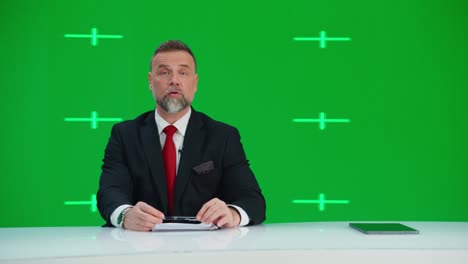 newsroom tv studio live news program with green screen background: male presenter reporting, talking. television cable channel anchor. network broadcast mock-up playback with tracking markers