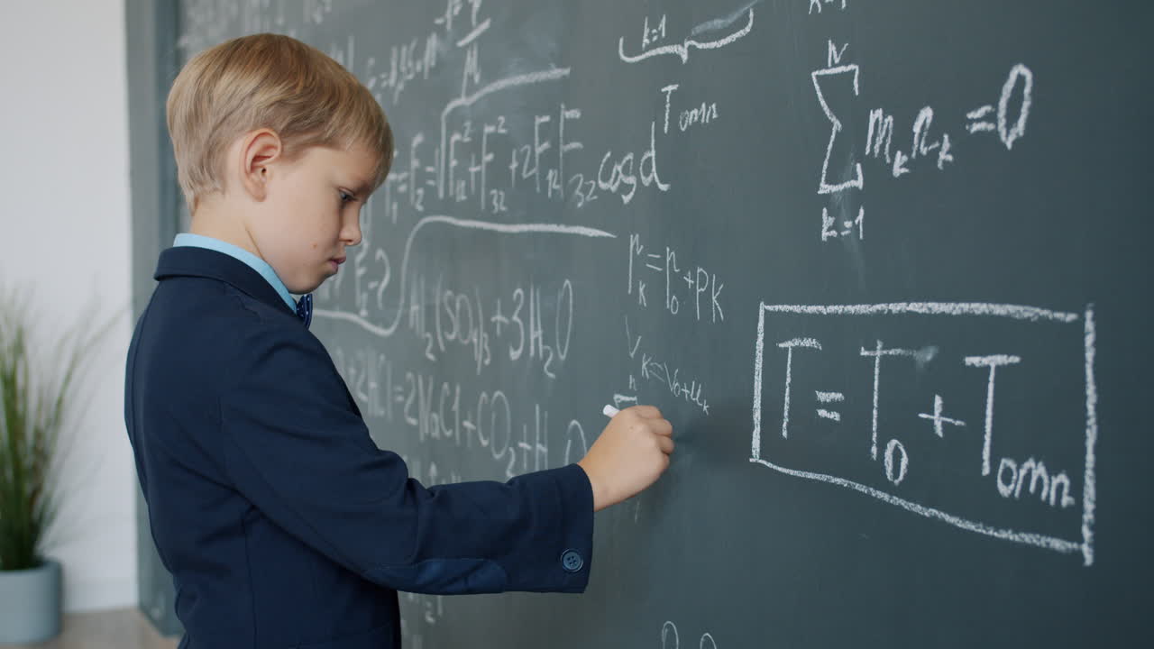 Young Boy Working on Math Equations on a Chalkboard