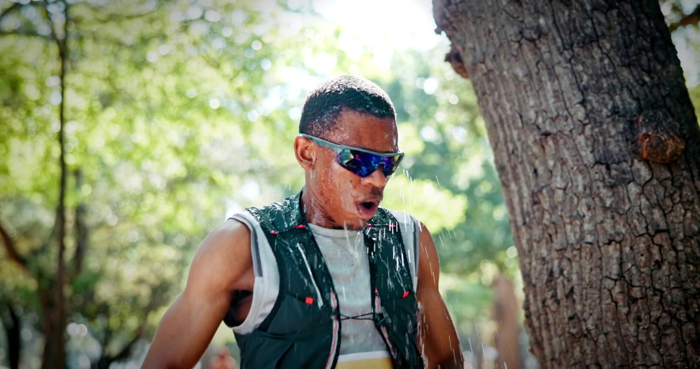 Exhausted Runner Cooling Down with Water in Park