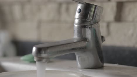 old faucet with running water being turned on and off in close-up 4k footage