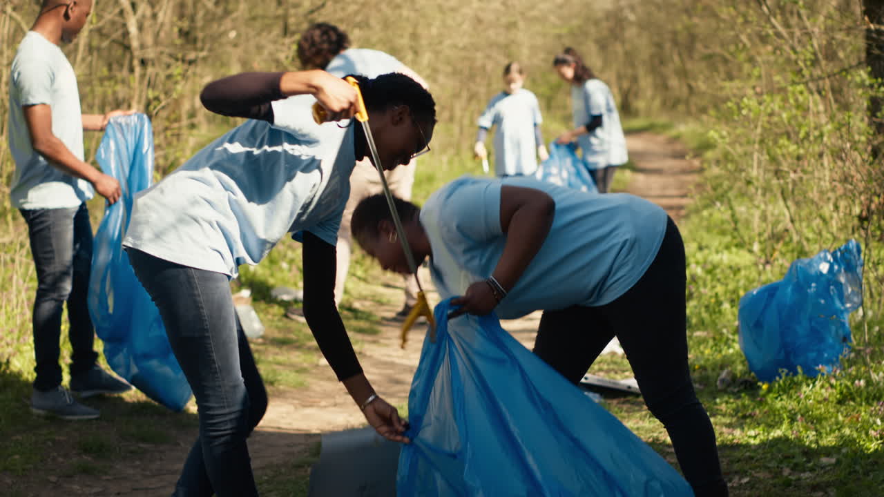Afrikansk amerikansk team af frivillige, der samler affald op fra jorden