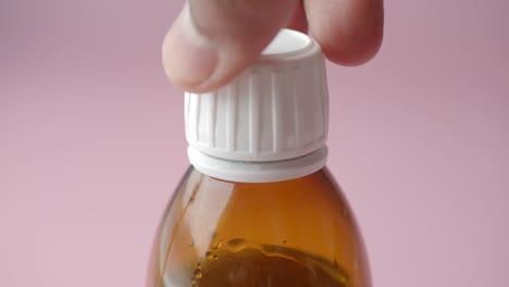 hand opening a medicine bottle cap