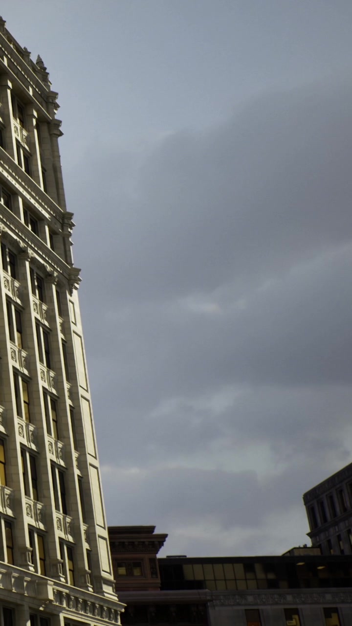 Edifício histórico sob um céu dramático em um centro de cidade movimentado