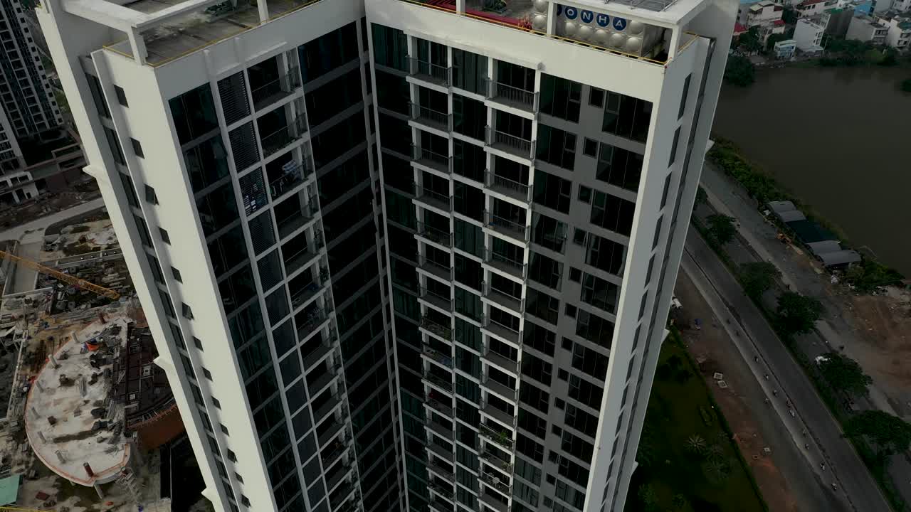 la grúa aérea descendente derribó un gran desarrollo de viviendas residenciales de gran altura del sudeste asiático con la expansión urbana en el fondo