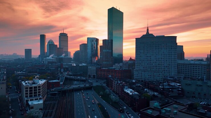 Splendido skyline della moderna Boston, Massachusetts, USA, sullo sfondo di un cielo rosa nuvoloso. Riprese con drone sopra la vivace città al crepuscolo