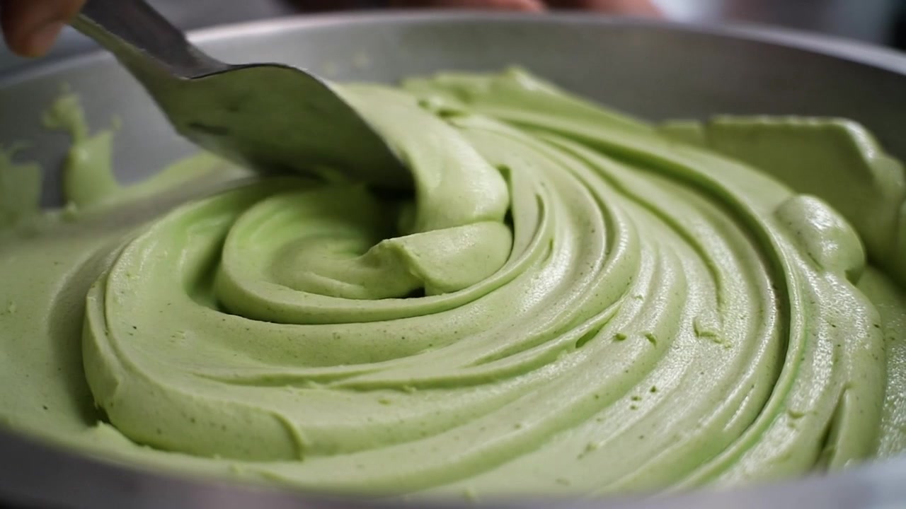 Chef Mixing Creamy Green Matcha Mousse in a Metal Bowl