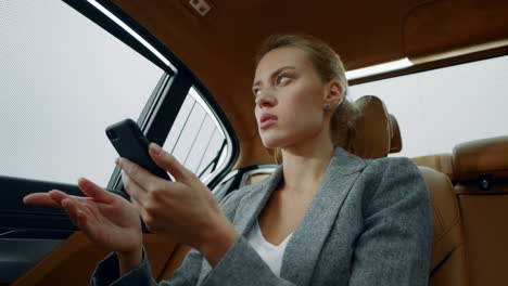 retrato de una mujer escribiendo una carta en el teléfono en un coche de lujo. una chica pensando en un vehículo