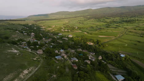 panorama aéreo del pueblo de chobareti con tierras de cultivo escénicas y fondo montañoso en el sur de georgia