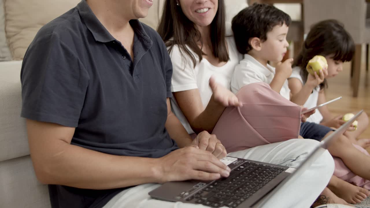 pareja de padres alegres usando computadoras y navegando por internet