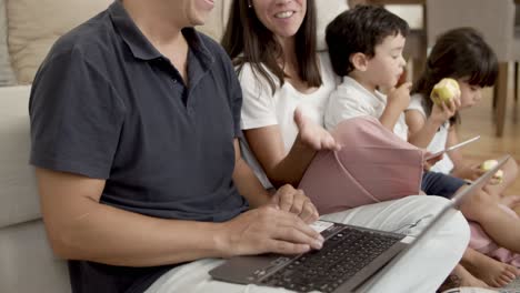 pareja de padres alegres usando computadoras y navegando por internet