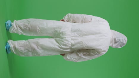 full body back view of asian male scientist having a headache while standing on green screen background