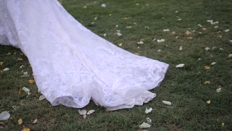 bride walking long veil falls on grass, cinematic slow motion bridal detail outdoors