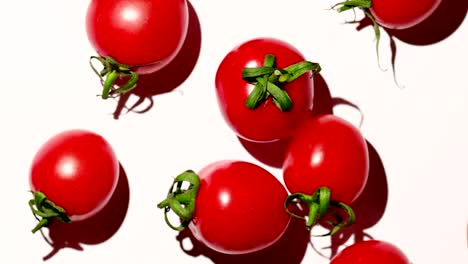 tomates de cereza girando sobre un fondo blanco, un ligero zoom hacia afuera
