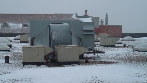 Rooftop-medium-shot-of-the-apartment-building-in-winter-time-with-HVAC-system