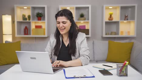 Mujer-Trabajadora-De-Oficina-En-Casa-Leyendo-Buenas-Noticias-Y-Sintiéndose-Feliz.