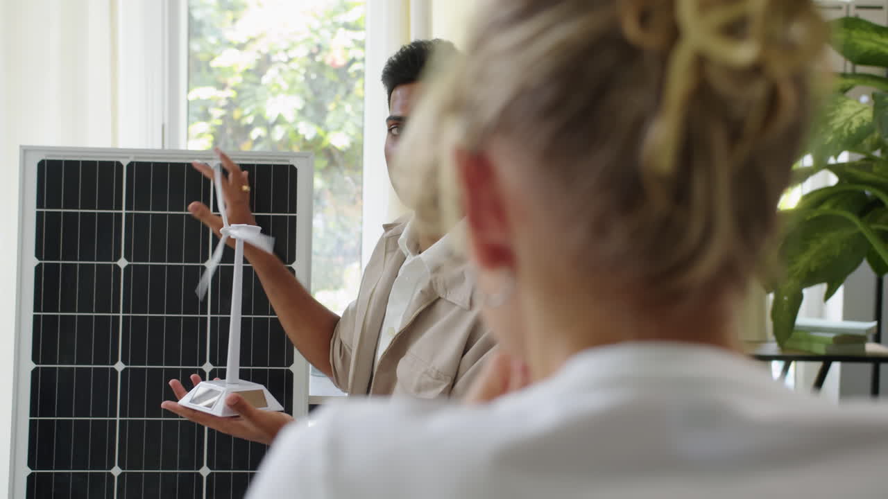 Specialist Comparing Advantages of Wind and Solar Power for Client