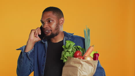 Young-adult-answering-a-phone-call-during-grocery-shopping-session