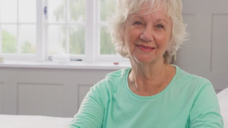 Portrait-Of-Smiling-Senior-Woman-At-Home-Using-Walking-Frame-To-Get-Out-Of-Bed