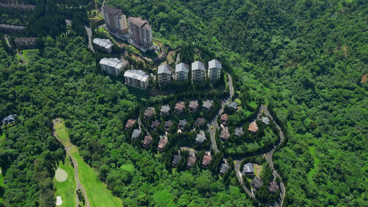 An overhead aerial of a Woodlands villa in Tagaytay Highlands surrounded by pine trees and winding roads in Batangas, Philippines