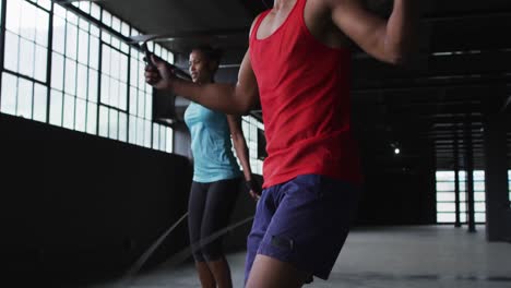 Hombre-Y-Mujer-Afroamericanos-Saltando-La-Cuerda-En-Un-Edificio-Urbano-Vacío