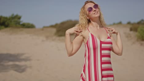 portrait of a beautiful young woman enjoying the warm sun while standing in stunning white sand dunes at the soestduinen, the netherlands