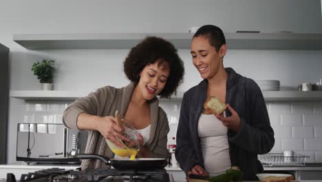 lesbian couple preparing breakfast in kitchen