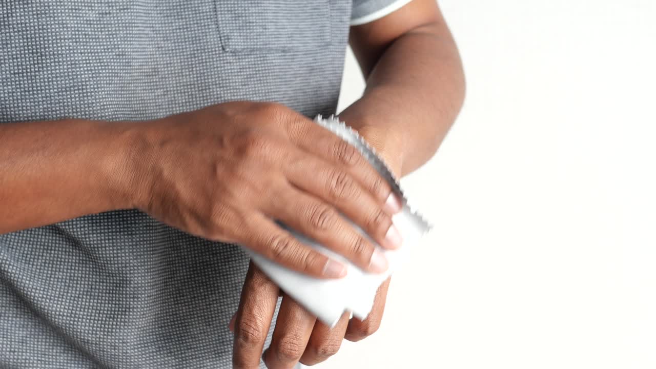 persona limpiándose la muñeca con un paño