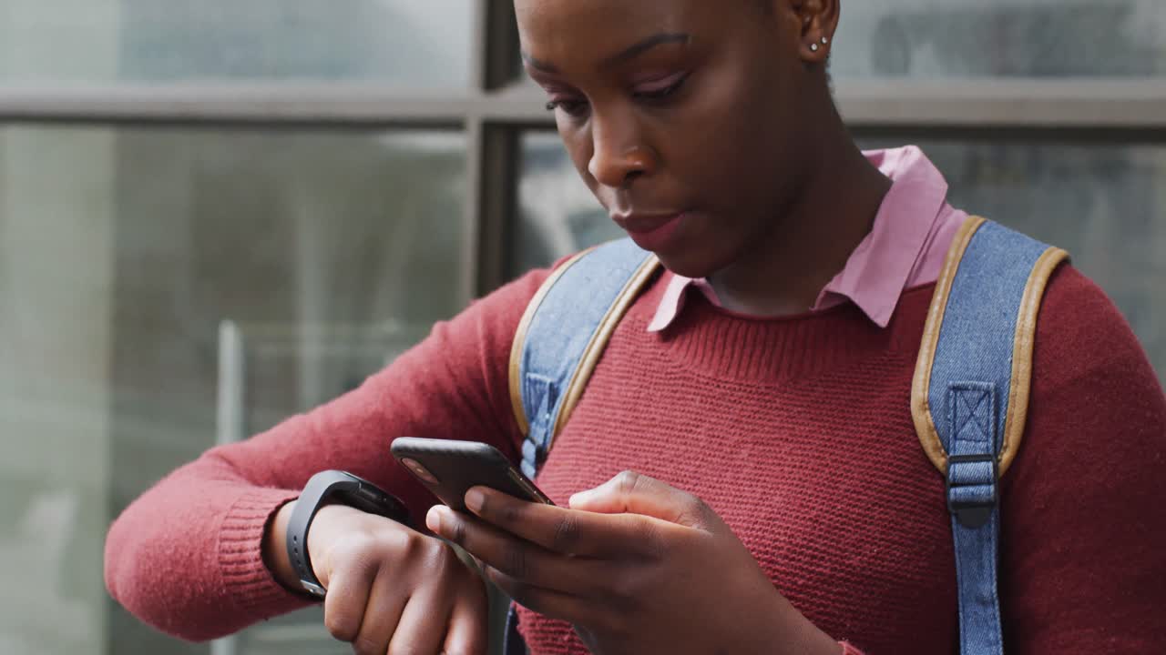 African american using her smartphone in street