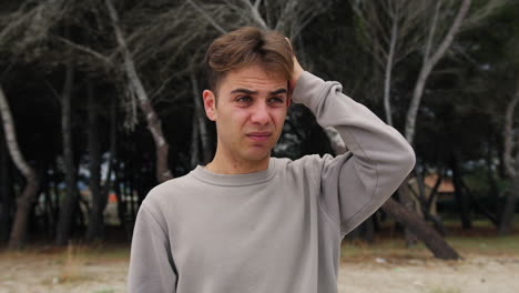 boy makes intimidated and ashamed expression in nature in a park