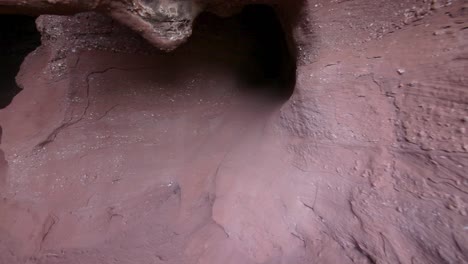 sandstone cliff with dark hole in daytime