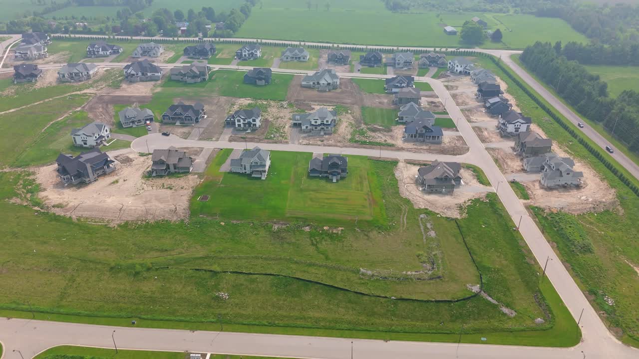 Drone establishing pullback above new housing development in Alton, Caledon under haze from Manitoba wildfire smoke