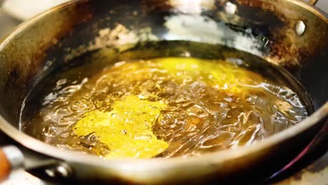 food frying in hot oil in a pan