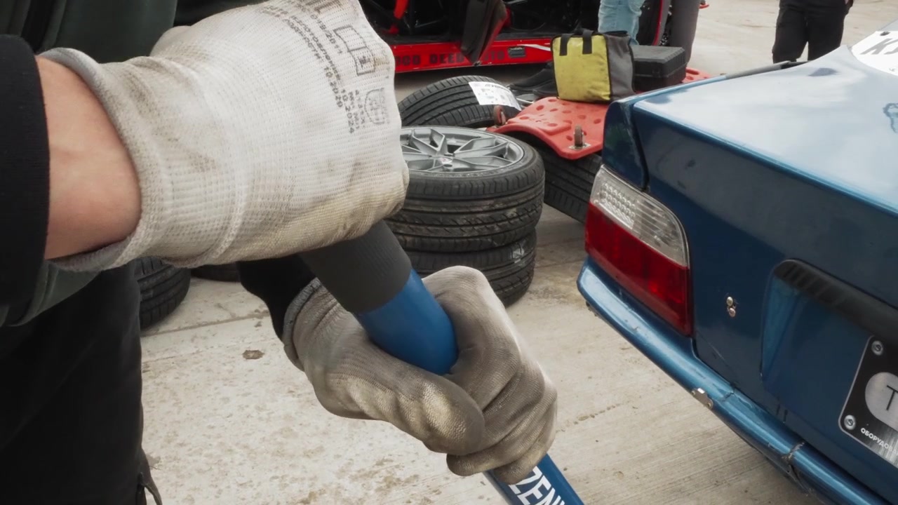 Close-up of Mechanic's Hands in Gloves Using a Tool