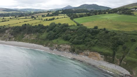 Bright-Blue-Sea-Rippling-And-Lush-Elevated-Shore-In-The-Beautiful-Beach-In-Greystones,-Wicklow-County,-Ireland---aerial