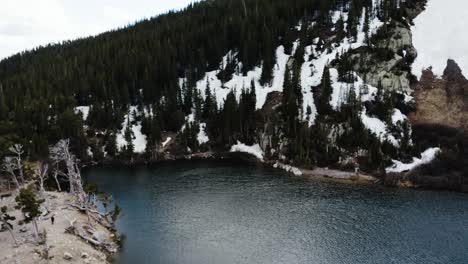 Drone-shot-flying-over-Saint-Mary's-Lake-with-wind-blowing-over-the-top-of-it