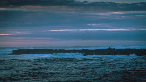 4k-time-lapse-of-sun-setting-over-Pacific-ocean-and-a-jetty-in-Bandon,-Oregon,-Dramatic-sky-and-wild-wave-action