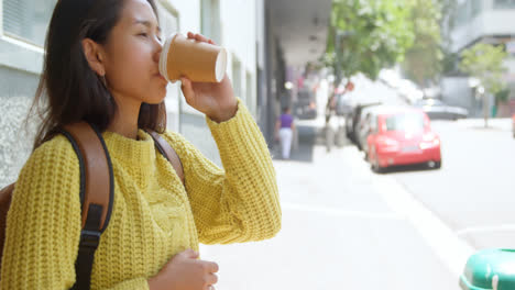 teenage girl drinking coffee on sidewalk 4k