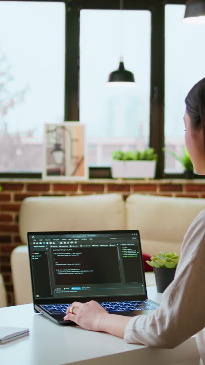 Vertical Video Professional asian software engineer is working remotely typing code on a laptop