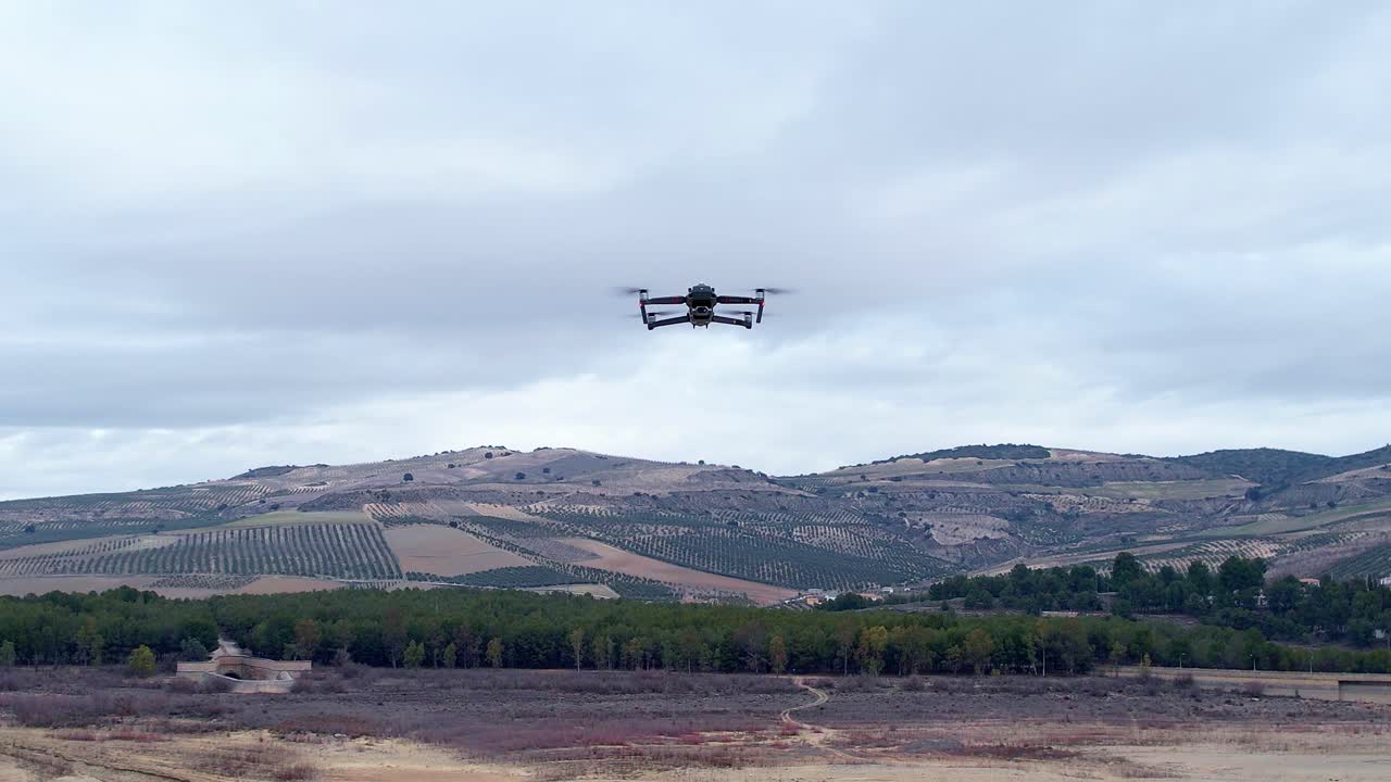 Drone in flight with position lights and signal flashes. Close aerial view. Zoom in. View of drone flying head-on and looking towards us with its camera.