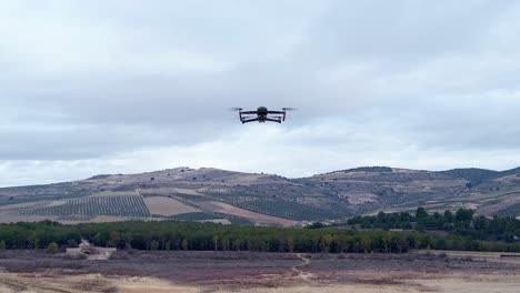 Drone in flight with position lights and signal flashes. Close aerial view. Zoom in. View of drone flying head-on and looking towards us with its camera.