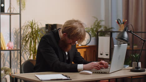 Aburrido-Y-Somnoliento-Trabajador-De-Negocios-Trabajando-En-Una-Computadora-Portátil,-Bostezando,-Quedándose-Dormido-En-La-Oficina-De-Casa