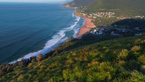 bald hill stanwell park beach tops aerial drone sunrise morning golden hour sea cliff bridge wollongong nsw australia sydney south coast illawarra coalcliff throull grand pacific drive forward pan up