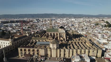 Cordoba-Mosque-Cathedral-with-Cityscape-as-background,-Aerial-Pullback